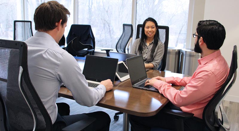 Three individuals in conversation during a business meeting